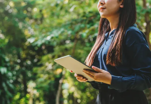 Un expert en performance environnementale analyse des données écologiques sur sa tablette en extérieur